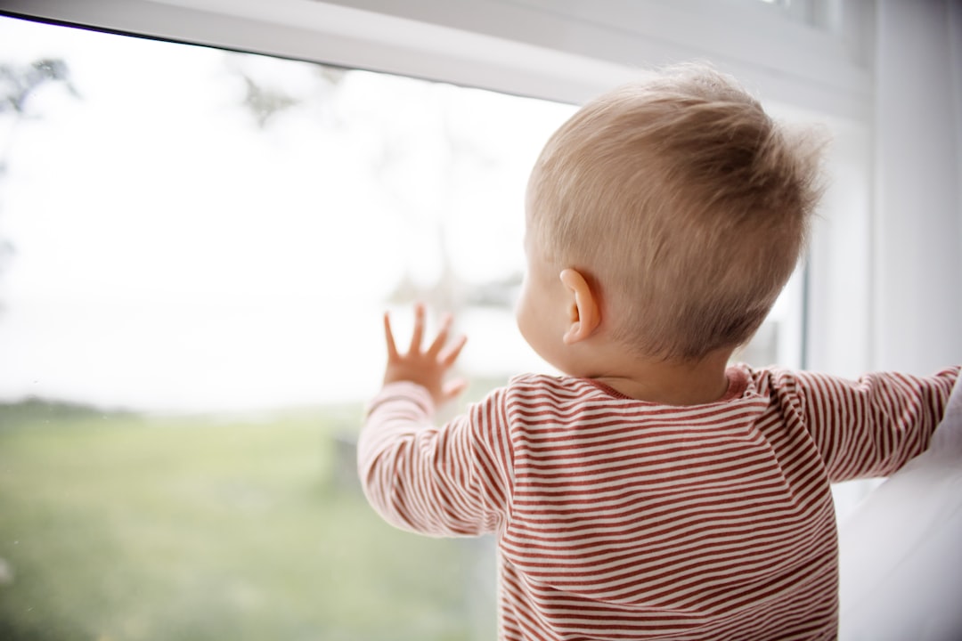 gyerek az ablaknál piros-fehér csíkos felsőben